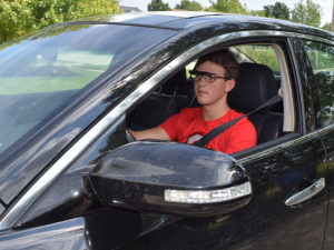 A young male bioptic driver operates a vehicle.