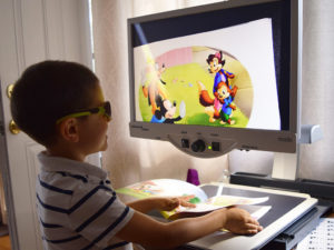 A vision impaired child users a computer program through UDS Low Vision Resource Center.